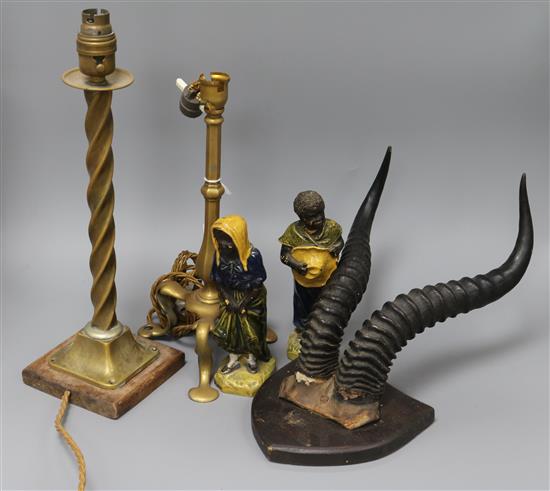 A pair of stoneware figures, mounted horns and two brass table lamps